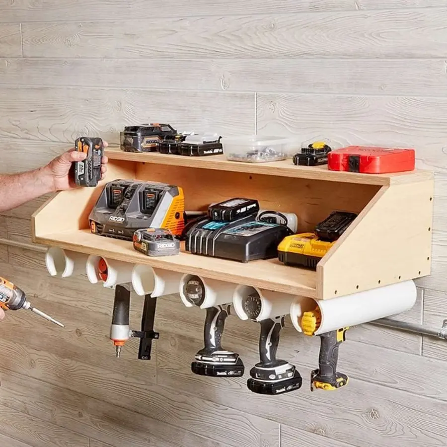 A wall-mounted organizer holds various cordless tools and batteries, illustrating garage tool storage.