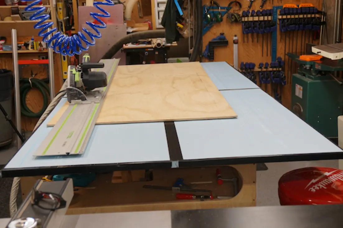 A track saw setup with plywood on a workbench, highlighting a portable cutting workflow.